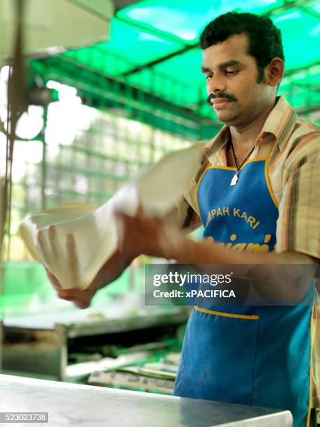 an indian malaysian preparing roti canai at an indian restaurant. - roti canai stock pictures, royalty-free photos & images