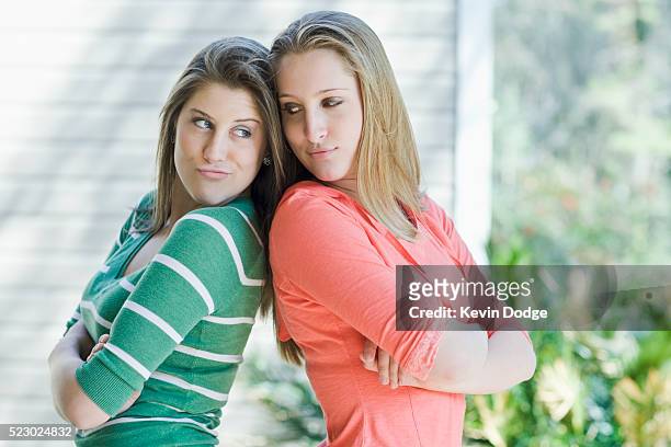 girls standing back to back - due sorelle foto e immagini stock