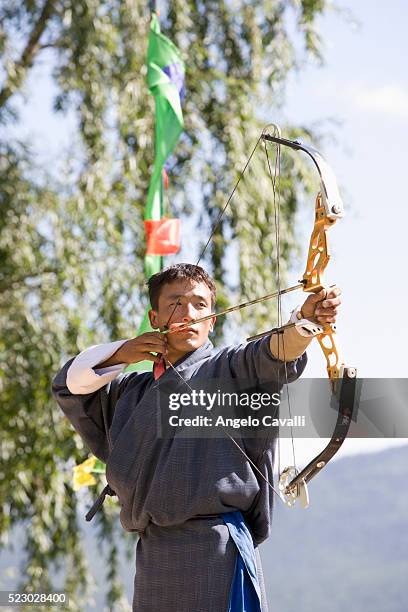 bhutanese archer in competition - bhutan archery stock pictures, royalty-free photos & images