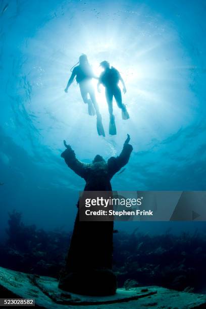scuba divers swimming above christ of the deep statue - the florida keys stock pictures, royalty-free photos & images