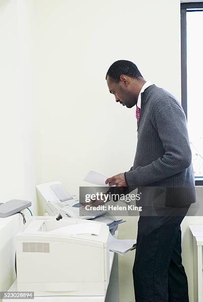 man sending a fax - faxmachine stockfoto's en -beelden