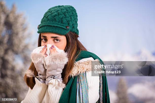 donna latina con influenza o allergie sneezes mentre all'esterno. inverno. - closeup of a hispanic woman sneezing foto e immagini stock