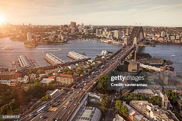 erhöhte panorama von sydney bei sonnenuntergang - hafenbrücke von sydney stock-fotos und bilder