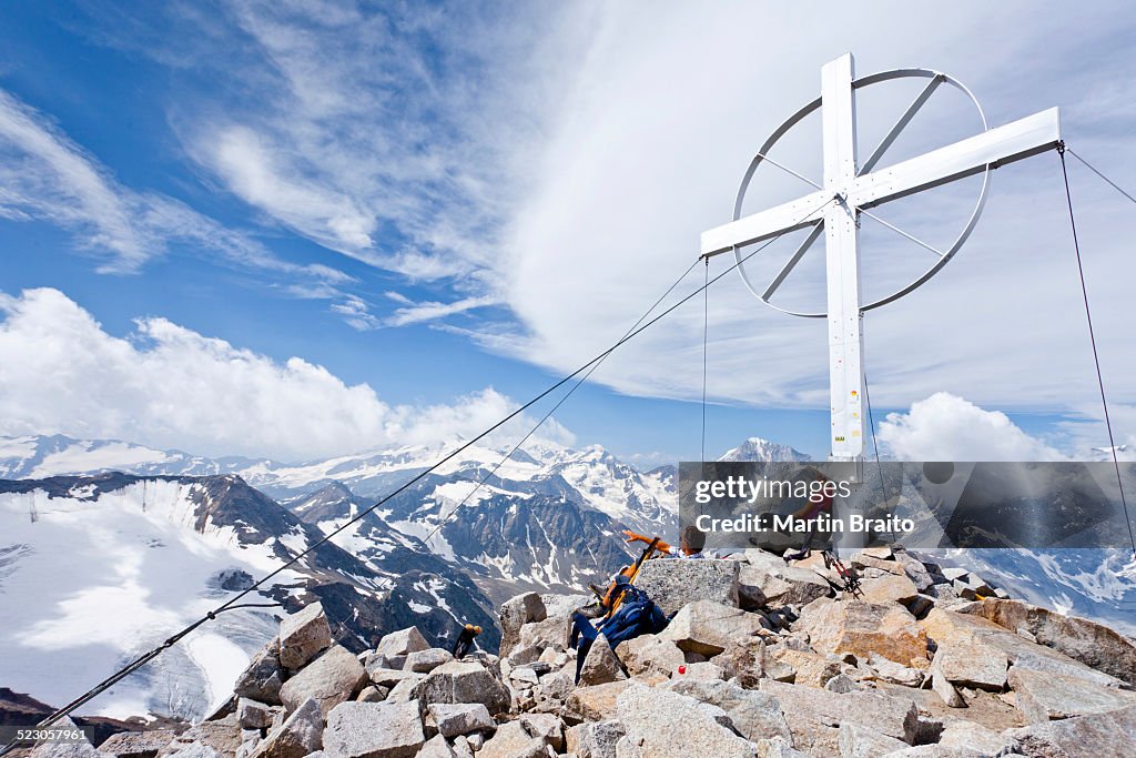 Climbers by the summit cross, Mt Vertainspitze, Ortler range, Mt Koenig at back South Tyrol, Italy, Europe