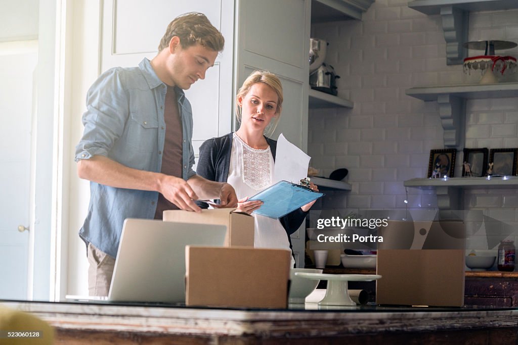 Young couple wrapping Christmas presents at home