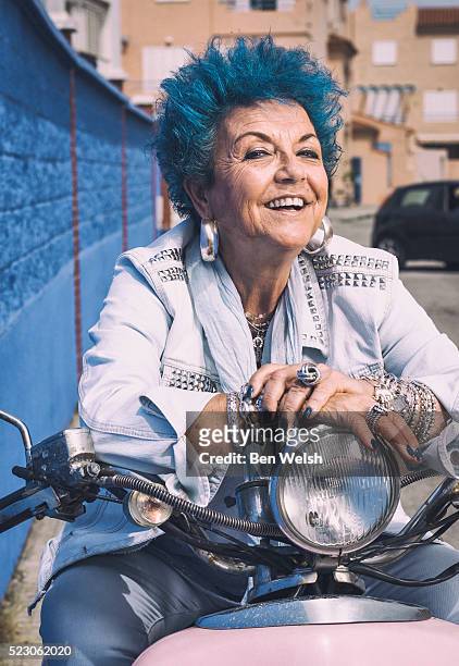 senior woman with blue hair on a motor bike. - old motorcycles imagens e fotografias de stock