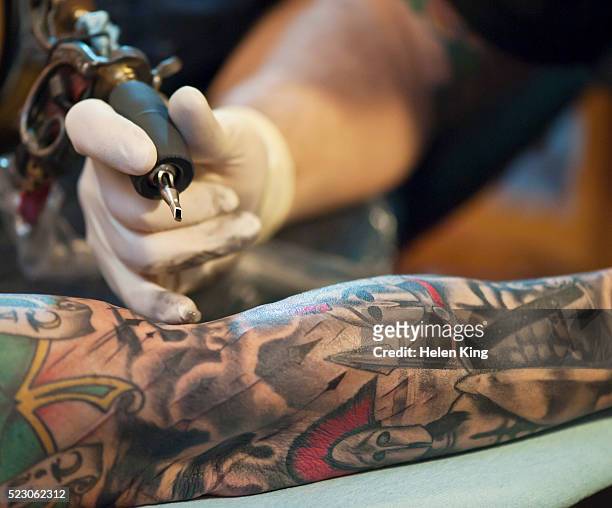tattoo artist at work - tatuaje fotografías e imágenes de stock