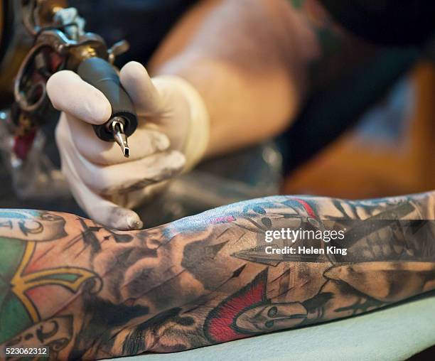 tattoo artist at work - tatuagem imagens e fotografias de stock