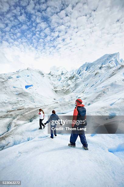 three people climbing on glacier - lake argentina stock pictures, royalty-free photos & images