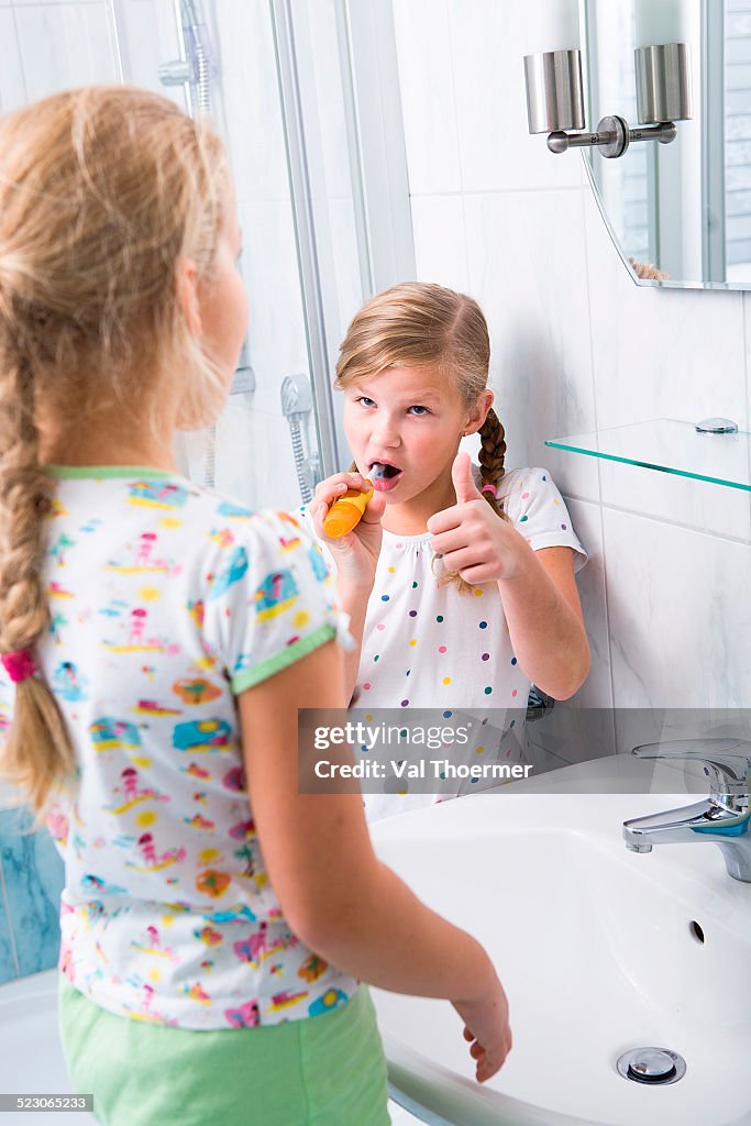 Sisters brushing teeth in the bathroom