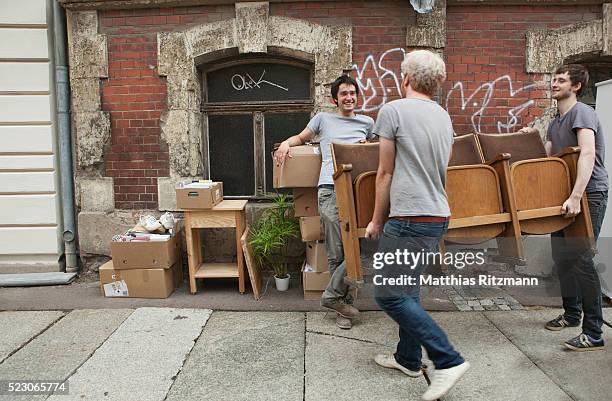 young men helping a friend move - moving furniture stock pictures, royalty-free photos & images