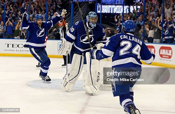 Victor Hedman, Ben Bishop and Ryan Callahan of the Tampa Bay Lightning celebrate a series win over the Detroit Red Wings after the third period in...