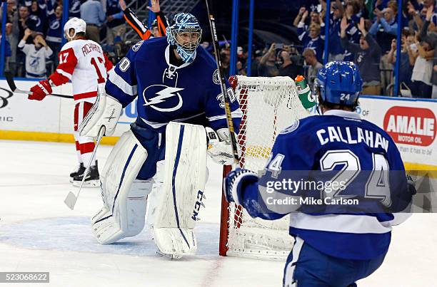 Ben Bishop of the Tampa Bay Lightning celebrates with Ryan Callahan as Brad Richards of the Detroit Red Wings reacts at the end of the third period...