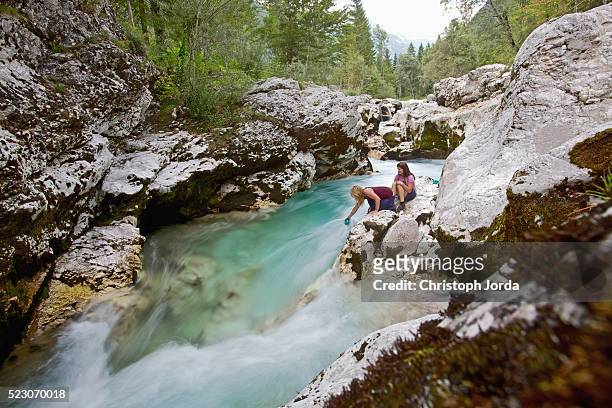 hikers sitting on mountain stream bank - slovenia austria stock pictures, royalty-free photos & images
