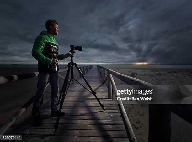 man taking photos at sunset. - photographer stock pictures, royalty-free photos & images