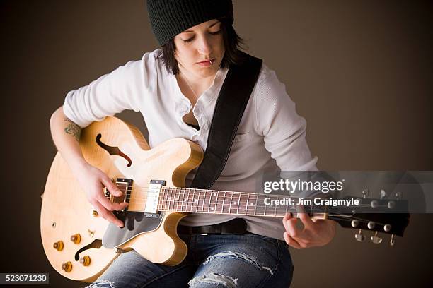 young woman playing semi hollow body electric guitar - jim craigmyle guitar stock pictures, royalty-free photos & images