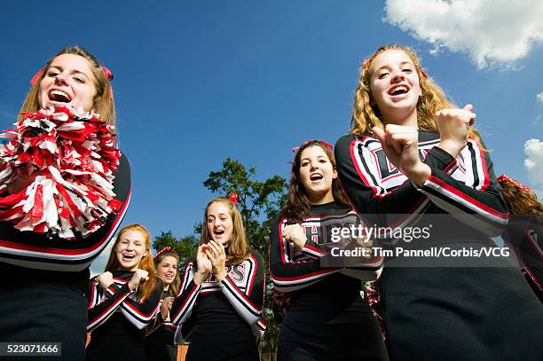 cheerleaders performing cheer - school cheerleaders stock pictures, royalty-free photos & images
