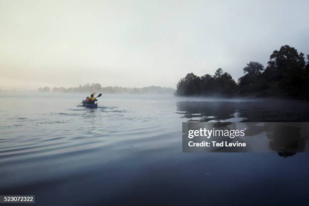 father and son (10-12) canoeing on lake in morning light, staffel lake, murnau, bavaria, germany - two people canoeing on a lake stock pictures, royalty-free photos & images
