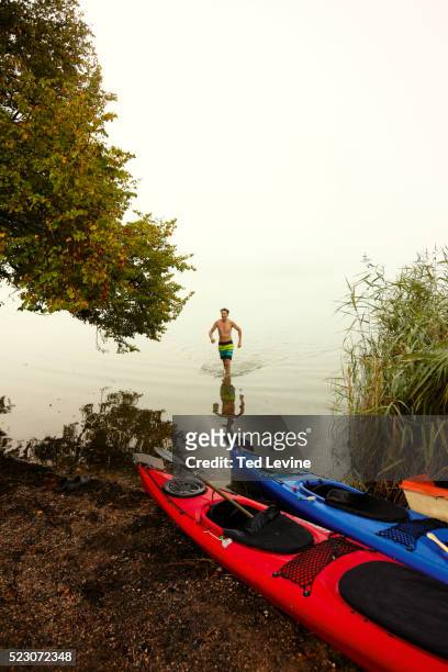 man walking in water, staffel lake, murnau, bavaria, germany - kanu männer stock-fotos und bilder