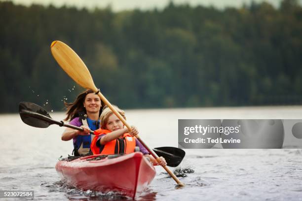 mother and son (10-12) canoeing on lake, staffel lake, murnau, bavaria, germany - kanoën stockfoto's en -beelden