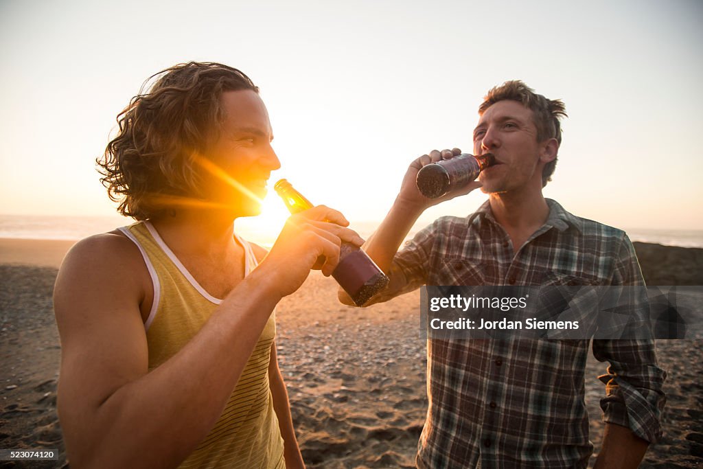 Two men drinking beer at sunset, Eureka, California, USA