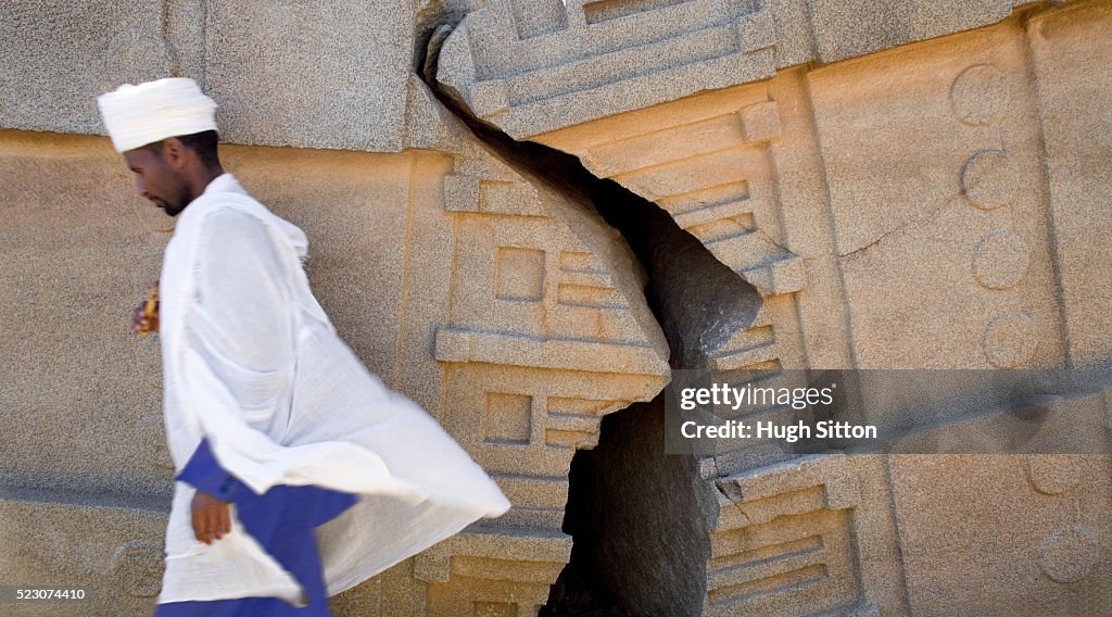 Man Walking Past Cracked Wall