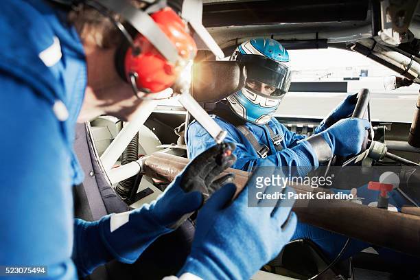 driver sitting in racecar and talking with coach - pilota di auto da corsa foto e immagini stock
