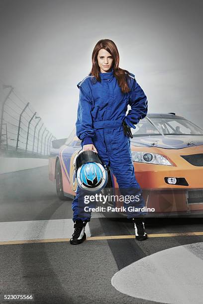 female race car driver standing in front of racecar - rennfahrer stock-fotos und bilder