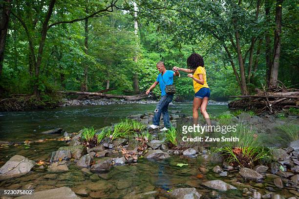 young couple walking in stream, coatesville, pennsylvania, usa - coatesville stock pictures, royalty-free photos & images