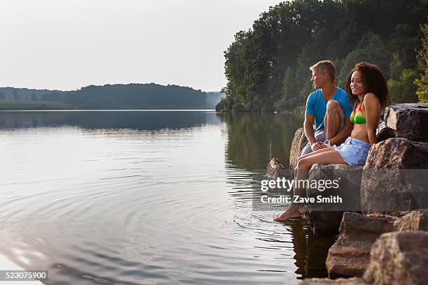 young couple sitting on river bank, coatesville, pennsylvania, usa - coatesville stock pictures, royalty-free photos & images