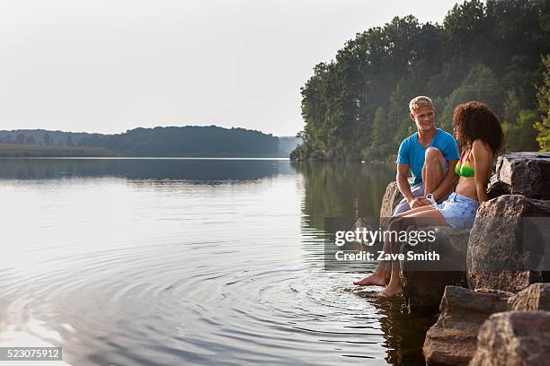 young couple sitting on river bank, coatesville, pennsylvania, usa - coatesville stock pictures, royalty-free photos & images