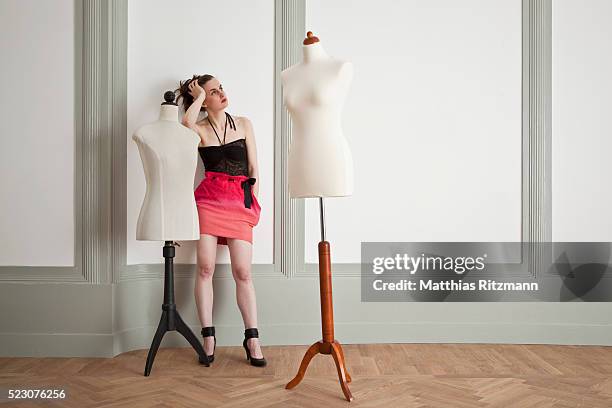 fashion model standing by tailor's dummy - schneiderpuppe stock-fotos und bilder