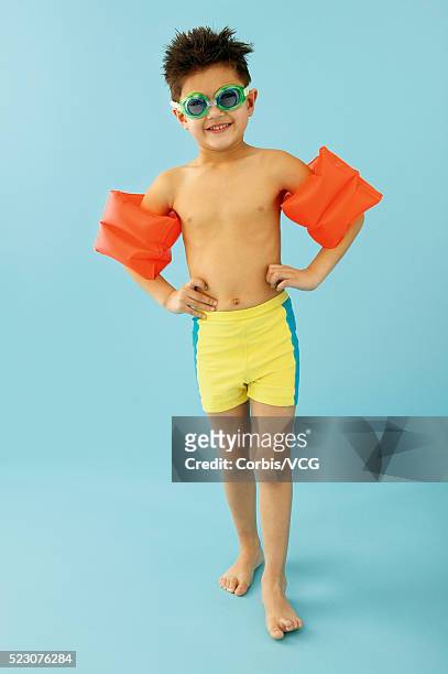 boy wearing swim trunks and water wings - boy in swimwear stock-fotos und bilder