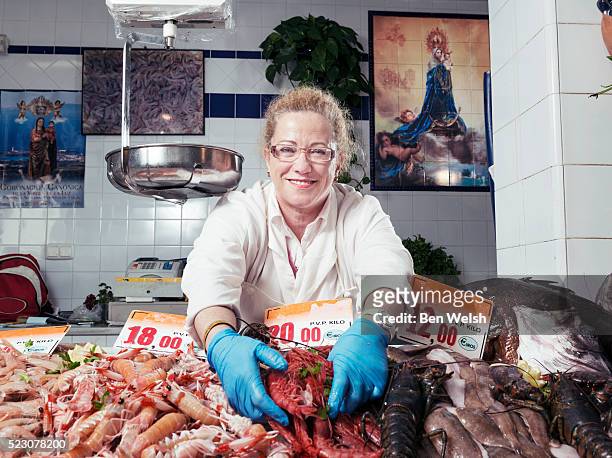 woman selling fish at market - fishmonger stock pictures, royalty-free photos & images