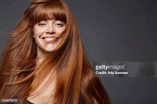studio portrait of young woman with long brown hair - pelirrojo fotografías e imágenes de stock