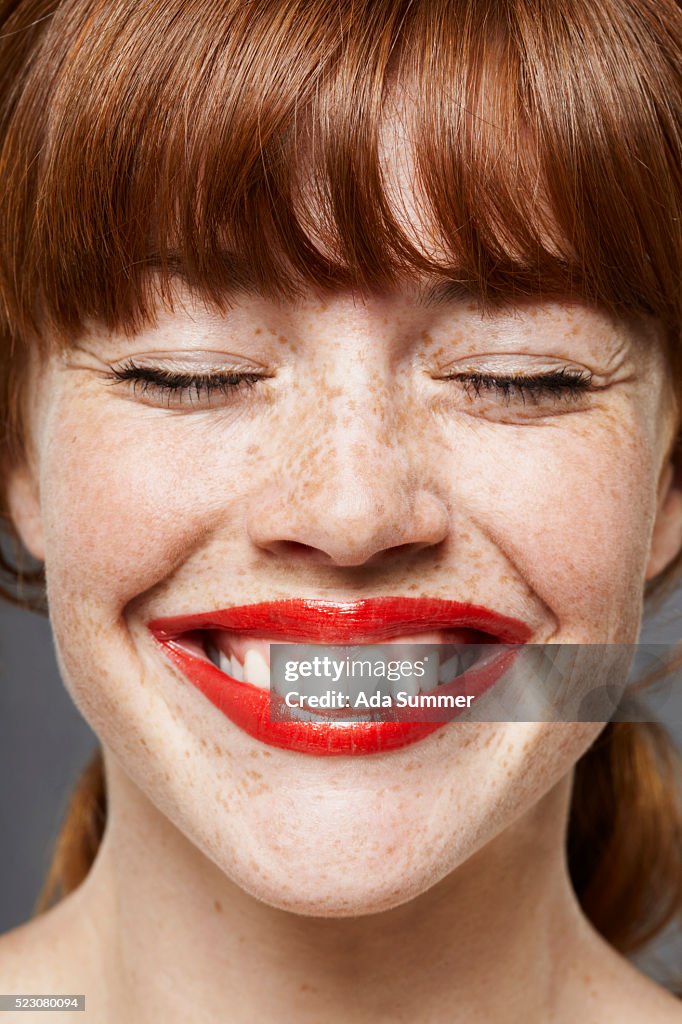 Young woman wearing lipstick, smiling