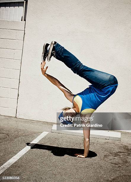 young woman breakdancing in parking lot - fare la verticale sulle mani foto e immagini stock