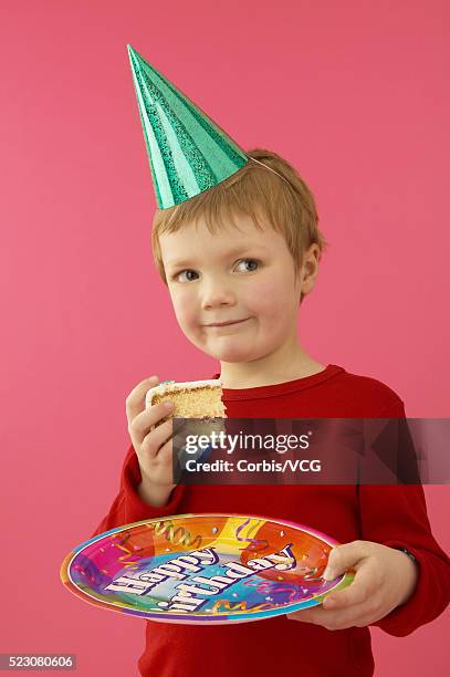 little boy holding birthday cake slice - party hat imagens e fotografias de stock