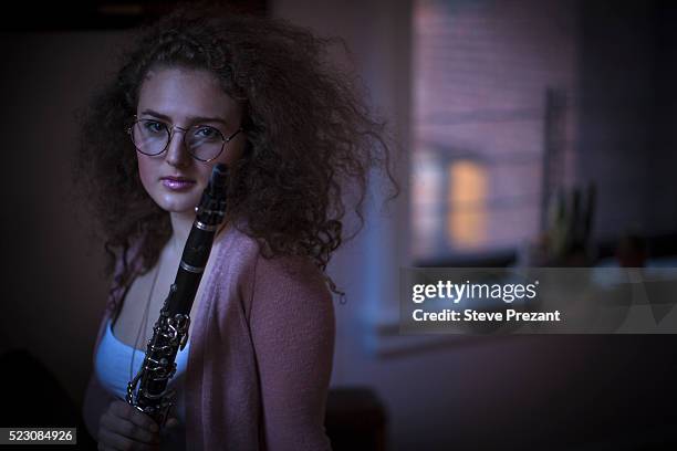 young woman holding clarinete - clarinete stockfoto's en -beelden