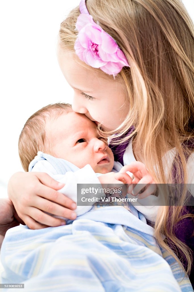 Baby boy, 1 month, being held by his sister