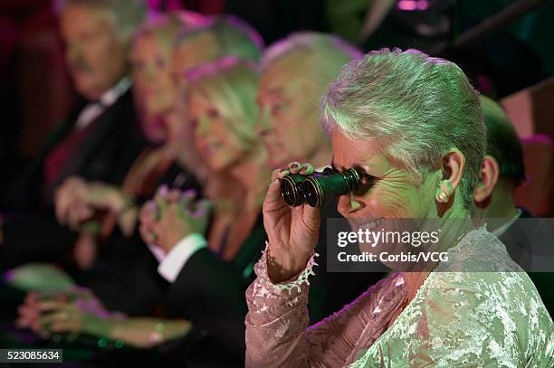 woman using opera glasses at the theater - opernglas stock-fotos und bilder