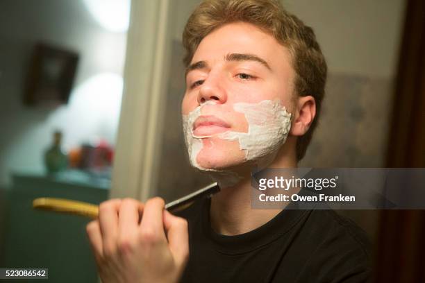young man shaving with a straight razor - safety shave razor stock-fotos und bilder