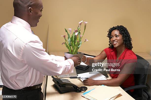 boss giving his administrative assistant flowers - administrative professionals day stockfoto's en -beelden