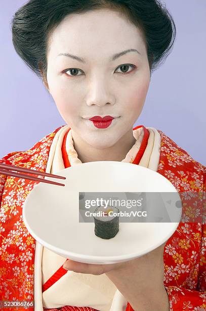 geisha holding sushi and chopsticks - geisha eating stockfoto's en -beelden