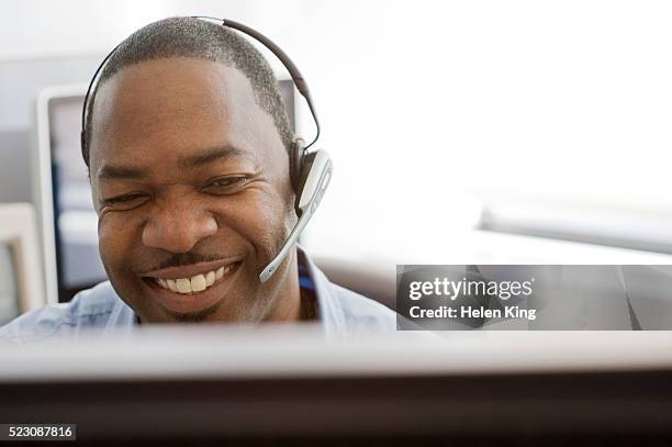 smiling businessman talking on headset - customer service representative stock pictures, royalty-free photos & images