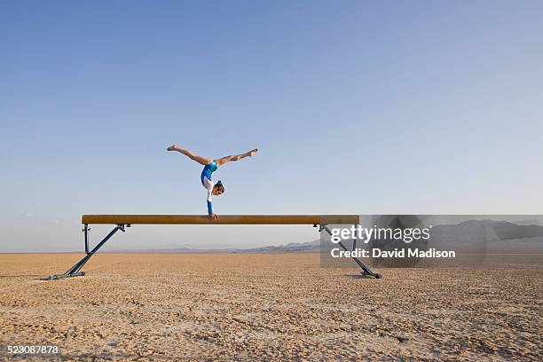 girl performing on balancing beam in the desert - trave foto e immagini stock