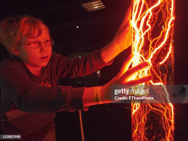 boy experimenting in science museum - natuurkunde stockfoto's en -beelden