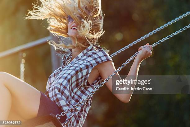 young woman swinging - minirock stock-fotos und bilder