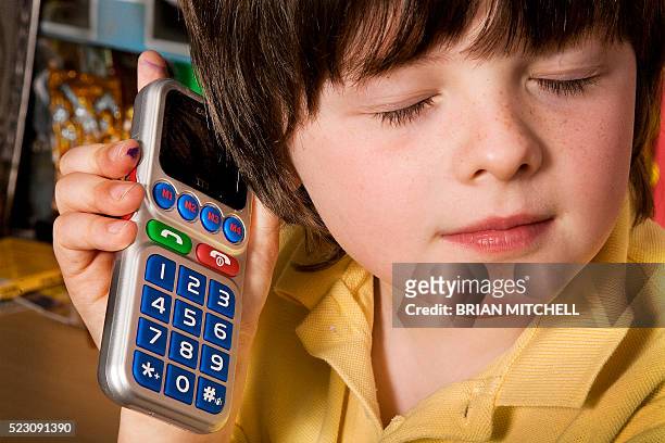 blind boy aged 7 using a special large button braille touch mobile cell phone for the visualy impared - assistive technology student stock pictures, royalty-free photos & images