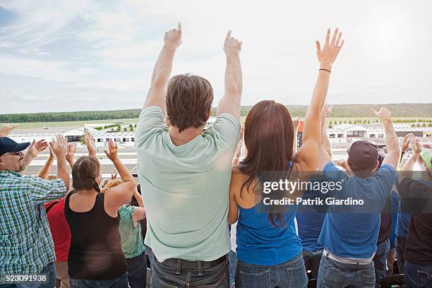 spectators watching car racing - watching nascar stock pictures, royalty-free photos & images